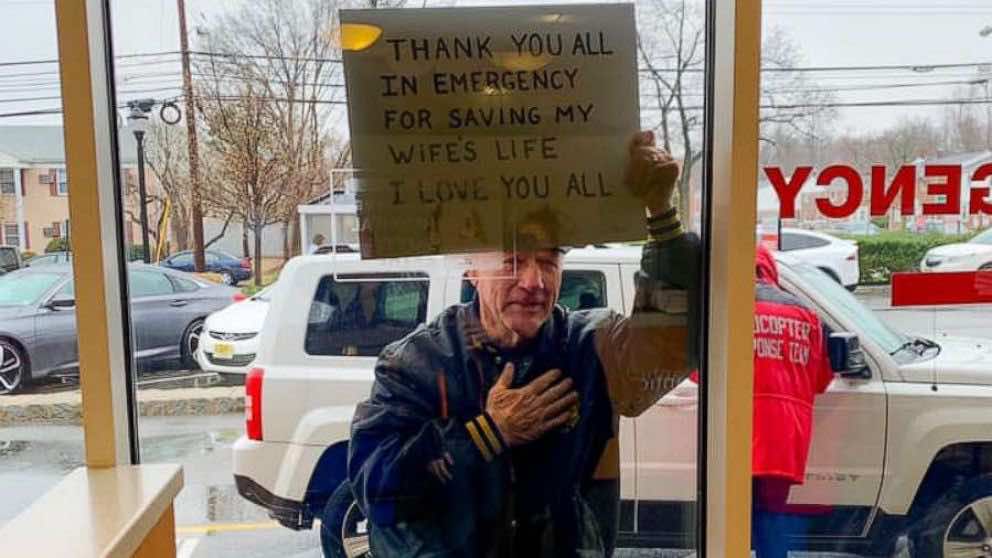Ηλικιωμένος με ευχαριστήριο πλακάτ στέκεται στην γυάλινη πόρτα