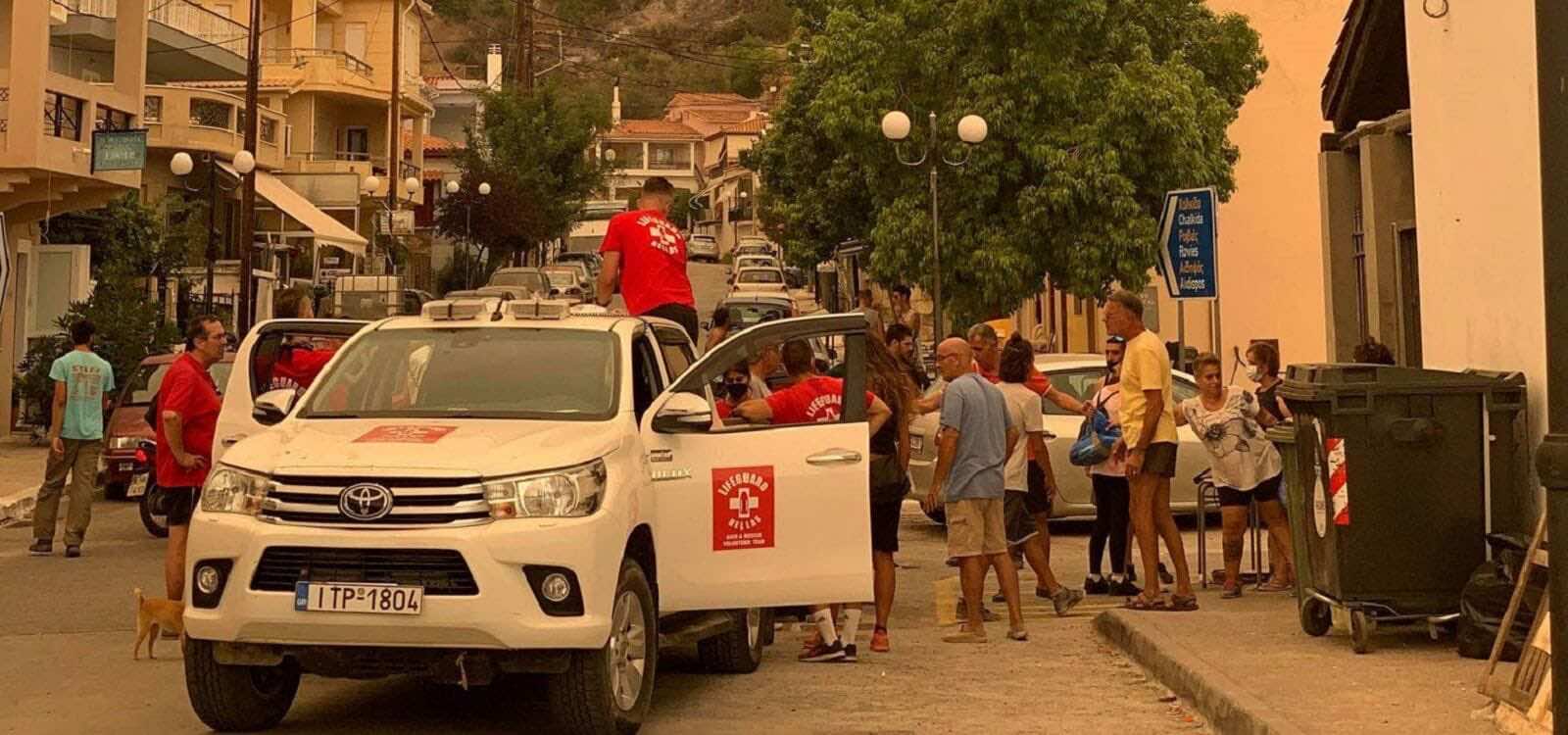 Άνθρωποι ο ένας δίπλα στον άλλο φορτώνουν είδη πρώτης ανάγκης σε αυτοκίνητο