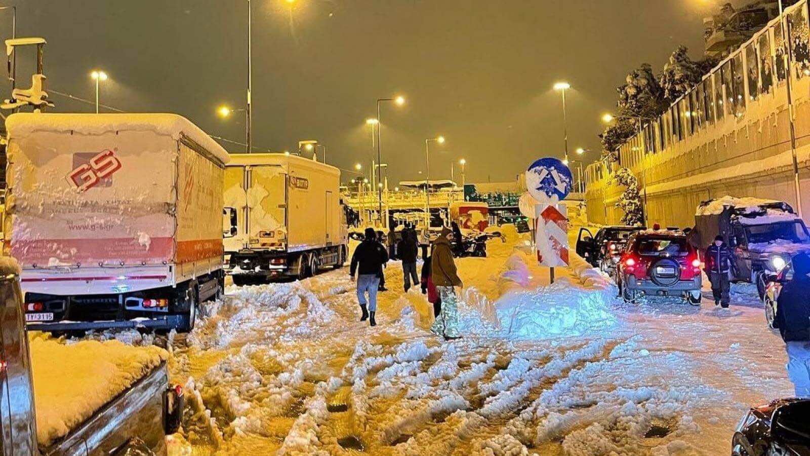 Δρόμος με χιόνια οχήματα σταματημένα κόσμος περπατά
