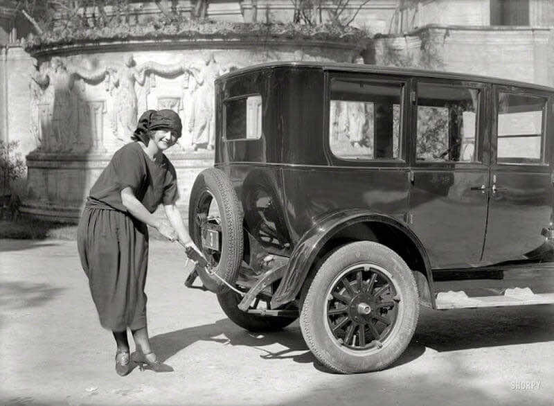 Γυναίκα δίπλα σε παλιό αυτοκίνητο, ασπρόμαυρη φωτογραφία