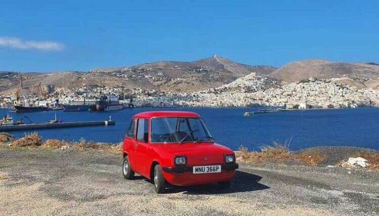 Κόκκινο Enfield με φόντο το λιμάνι της Σύρου