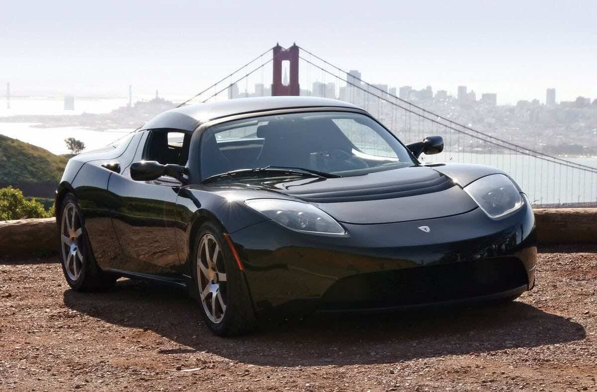 Μαύρο Tesla Roadster με φόντο γέφυρα