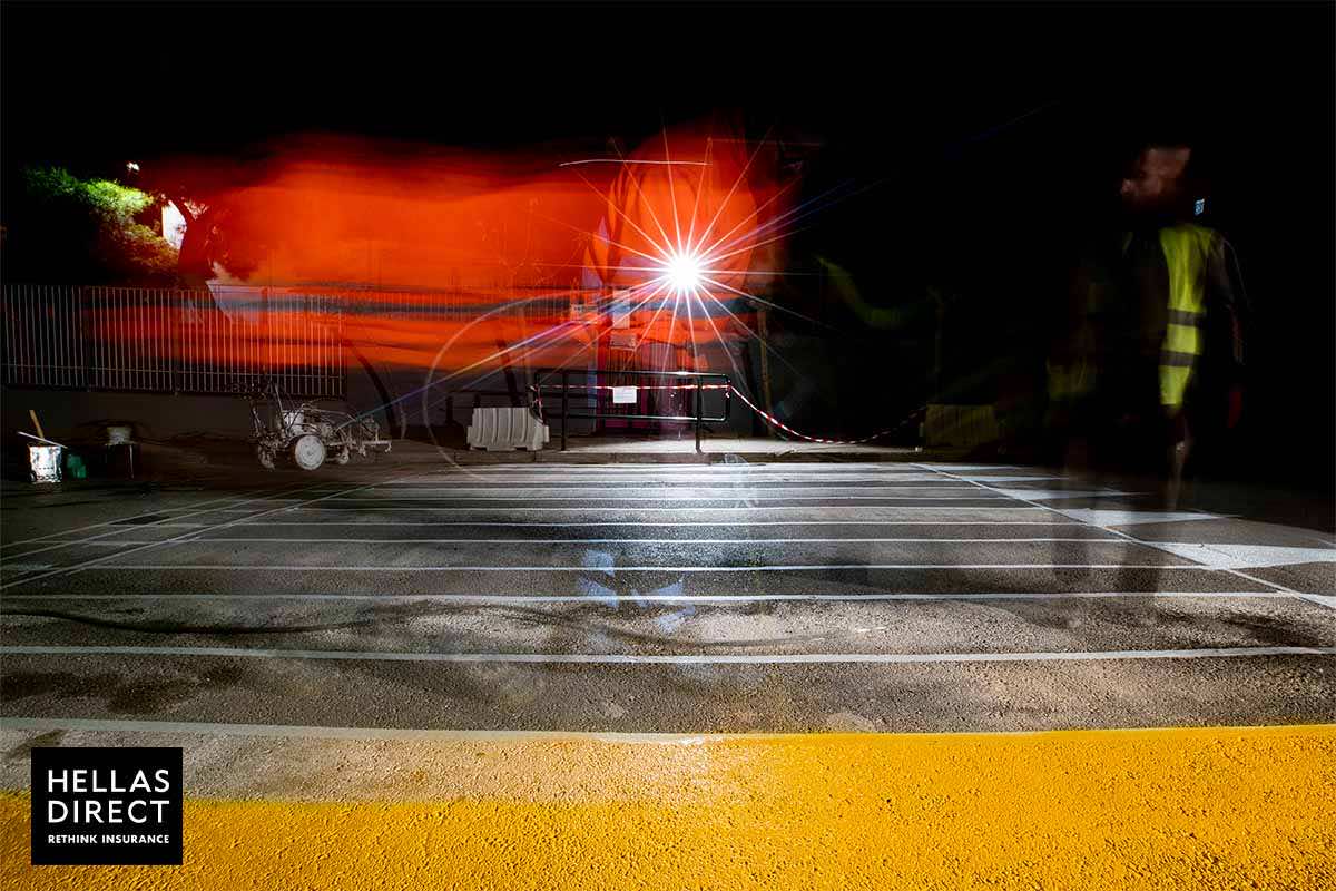 Νυχτερινή φωτογραφία με εργασίες στον δρόμο, μπροστά μας βάφεται μία διάβαση κίτρινη