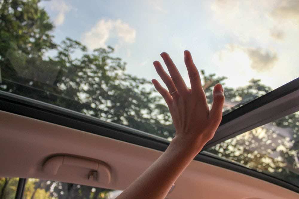 γυναικείο χέρι ακουμπά γυάλινη ηλιοροφή αυτοκινήτου