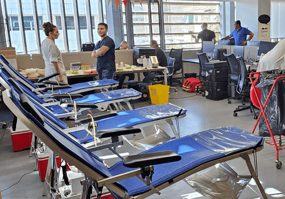 χώρος γραφείου με κρεβάτια αιμοδοσίας στη σειρά και νοσηλευτές