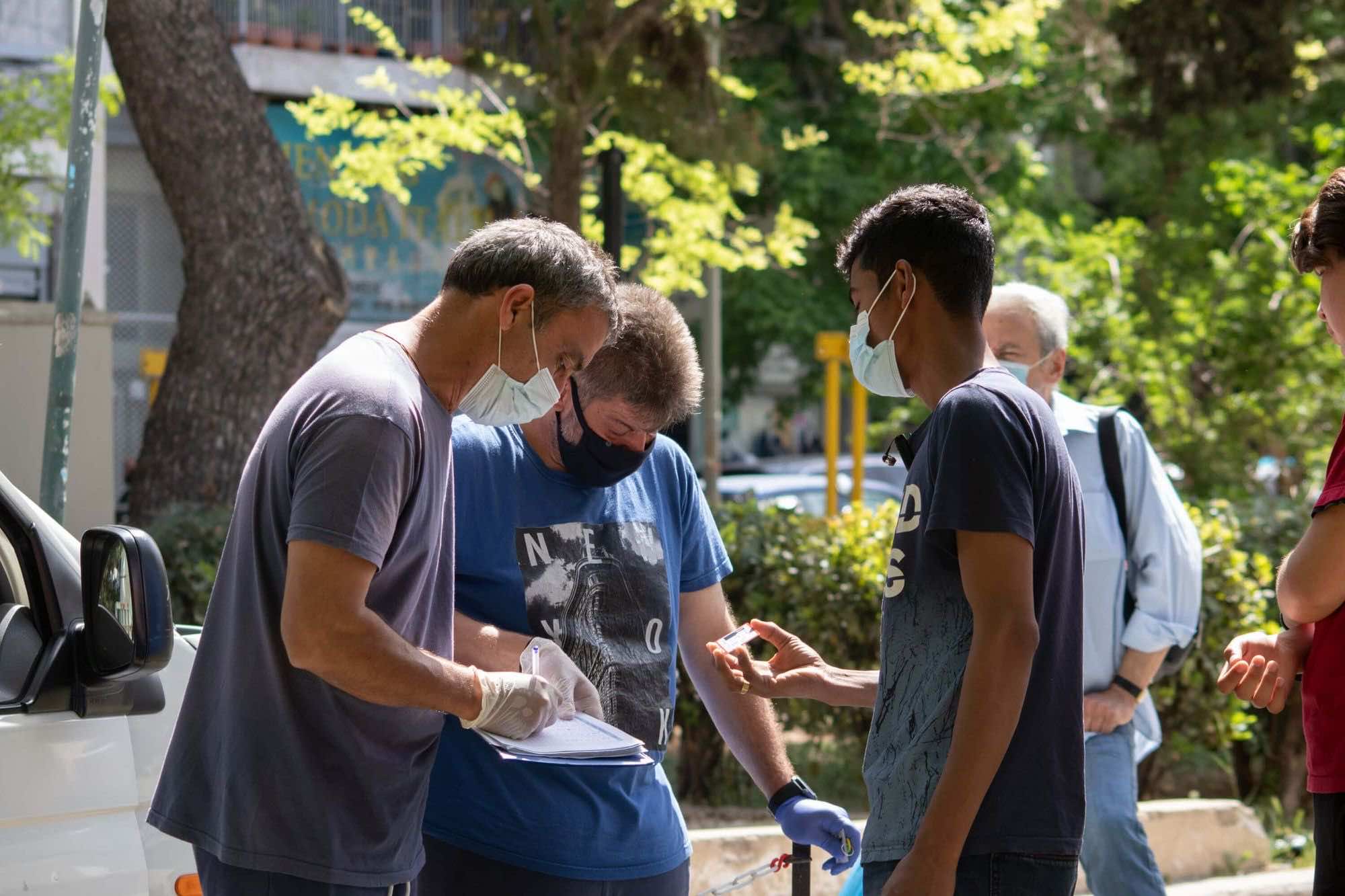 άνθρωποι με μάσκες κορονοϊού σημειώνουν