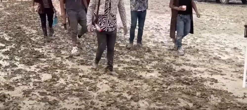 άνθρωποι βαδίζουν μέσα στη λάσπη