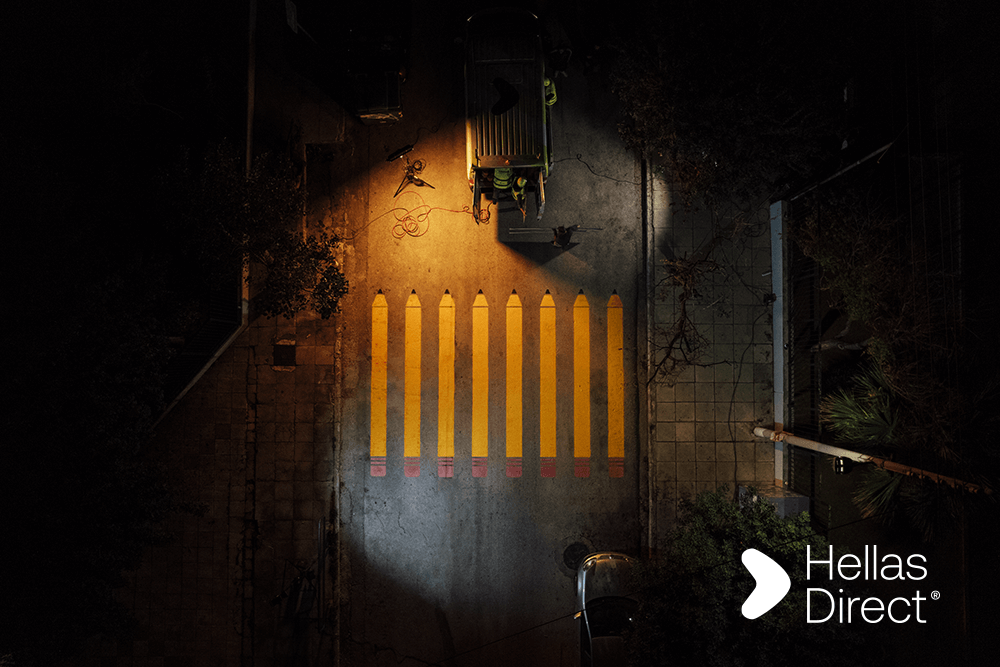 Διάβαση με κίτρινα μολύβια από drone shot, νύχτα, logo Hellas Direct