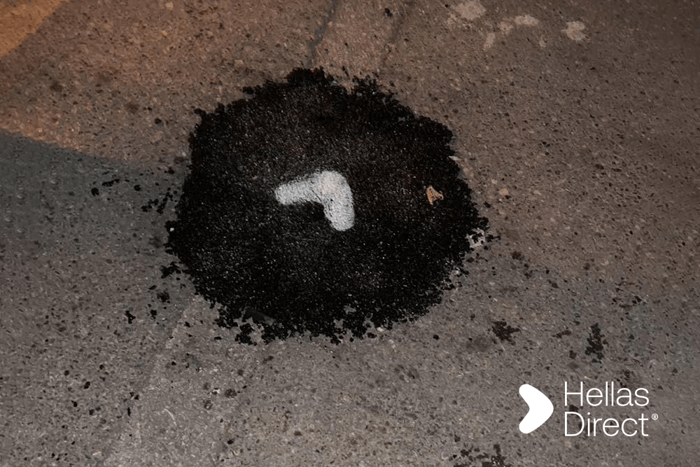 Λακκούβα φρεσκοφτιαγμένη με μαύρη άσφαλτο και λευκό σημάδι
