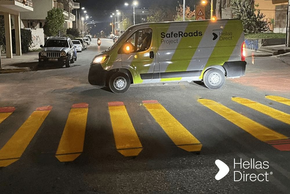 φρεσκοβαμμένη διάβαση πεζών με κίτρινα μολύβια, στο φόντο το βαν του Safe Roads project