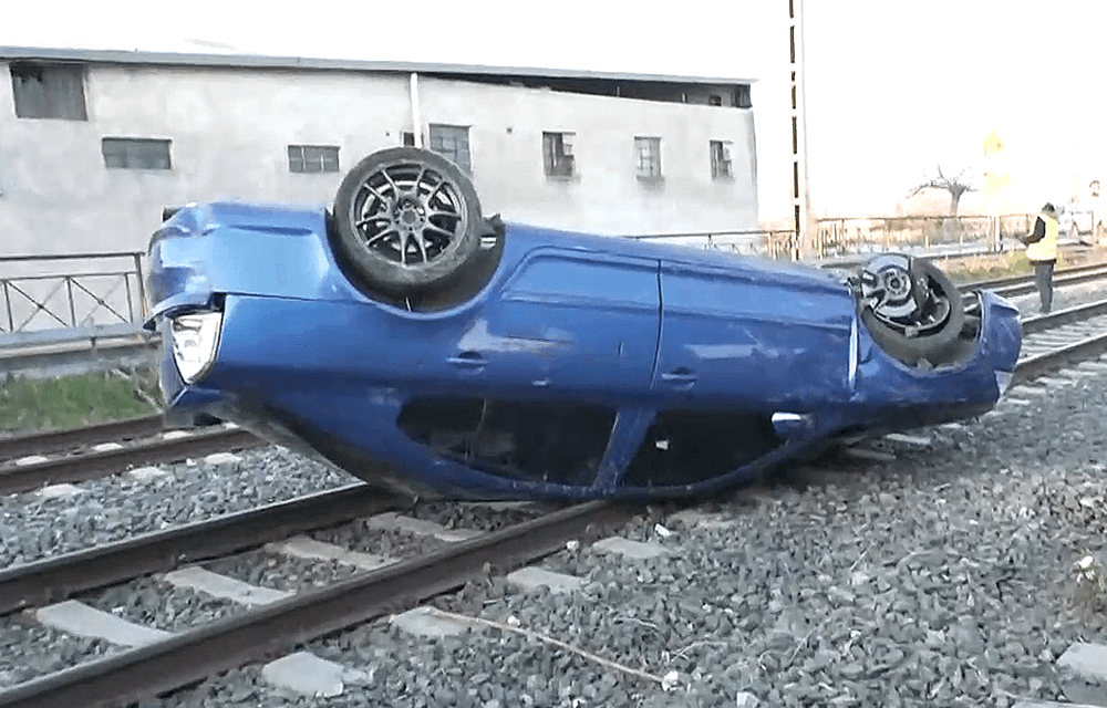 μπλε αυτοκίνητο αναποδογυρισμένο πάνω σε ράγες τρένου