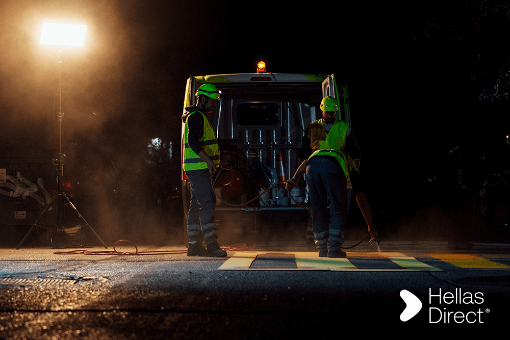 νύχτα στον δρόμο, το βαν του Safe Roads project από πίσω με ανοιχτή την πόρτα, δύο μέλη του συνεργείου όρθια