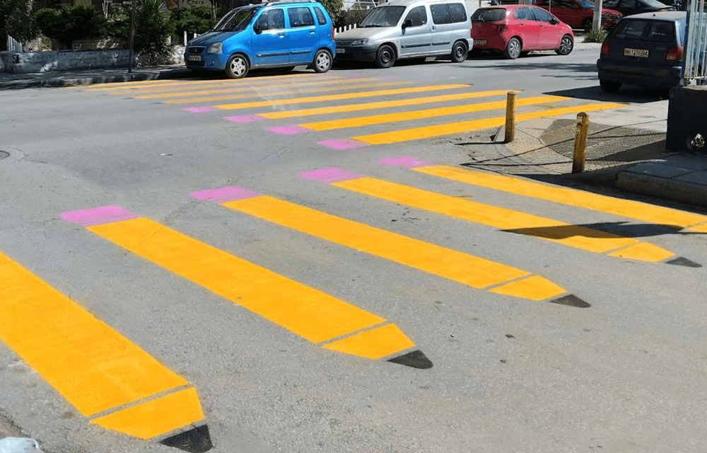 Διασταύρωση, πολύχρωμη διάβαση με σχέδιο μολυβια, στο φόντο παρκαρισμένα αυτοκίνητα