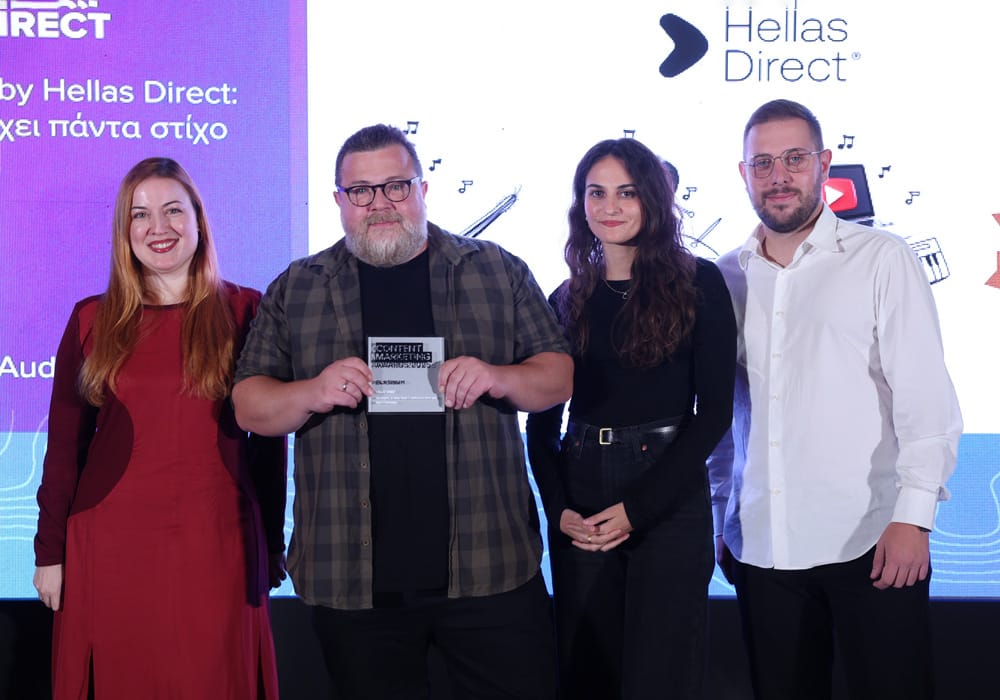 Η ομάδα της Hellas Direct όρθια παραλαμβάνει βραβείο στη σκηνή των Content Marketing Awards