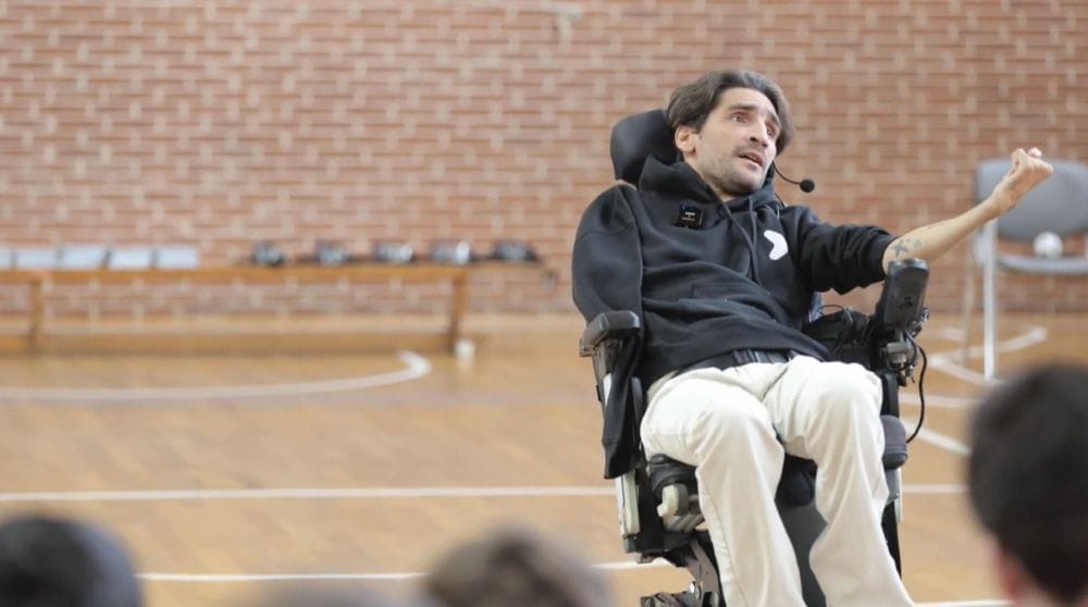 Ο Δημήτρης Αντωνίου ανφάς με φόντο κλειστό γήπεδο μπασκτε σχολείου