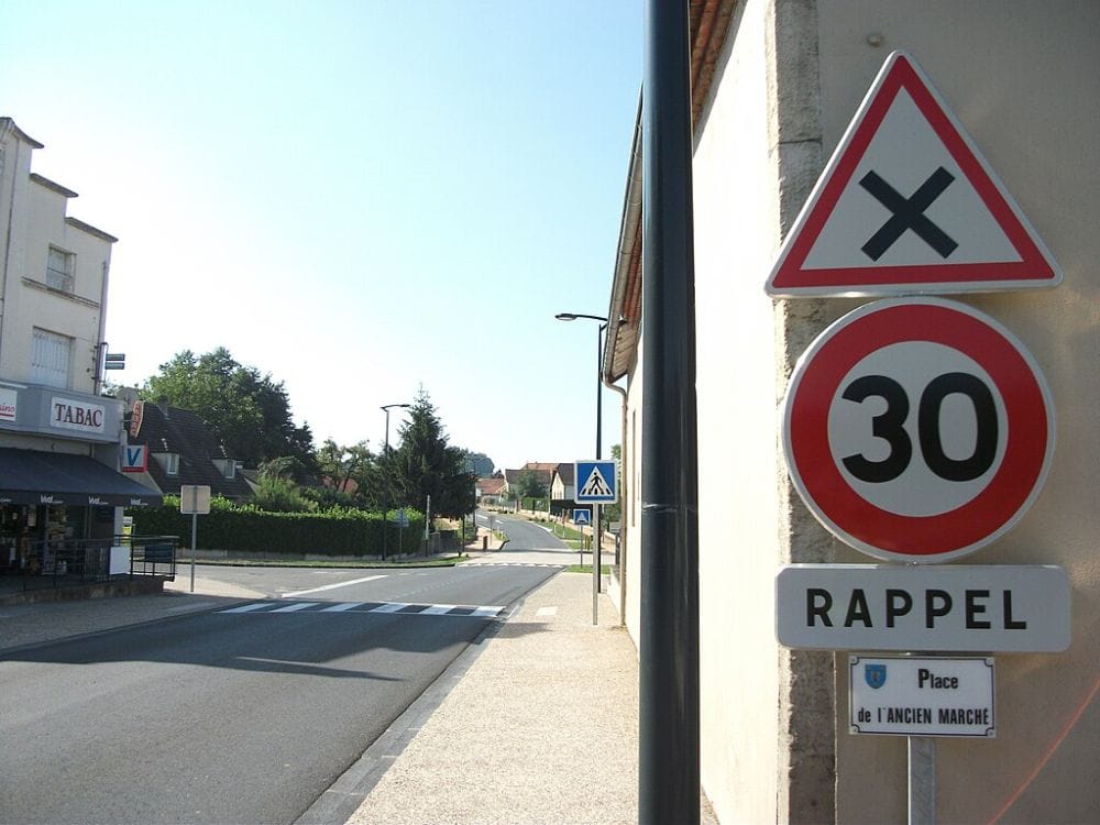 άδειος δρόμος στη Γαλλία, κοντινό σε πινακίδα για α όρια ταχύτητας στα 30 χλμ και παραχωρηση προτεραιότητας