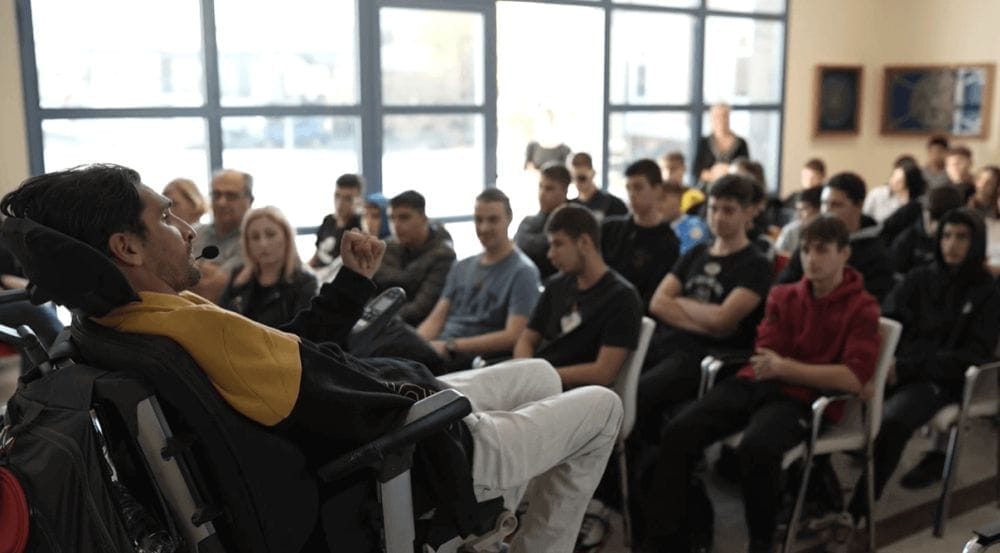 ο Δημήτρης Αντωνίου στο πλάι, μπροστά του μαθητές καθισμένοι τον κοιτούν