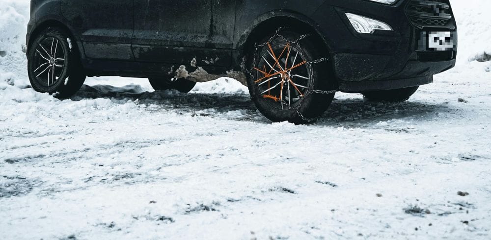 αυτοκίνητο πάνω σε χιονισμένι έδαφος, αντιολισθητικές αλυσίδες στον τροχό