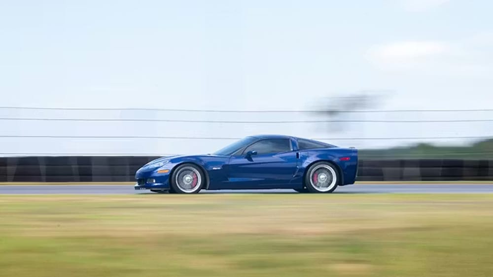 μπλέ Chevrolet Corvette Z06 από το πλάι εν κινήσει