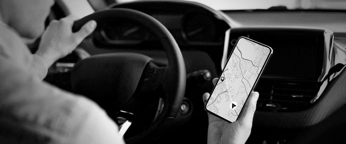 οδηγός κρατάει κινητό με χάρτη gps στην οθόνη 