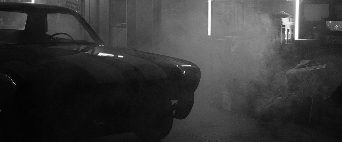 Vintage αυτοκίνητο στο συνεργείο με φόντο καπνούς, ασπρόμαυρη εικόνα