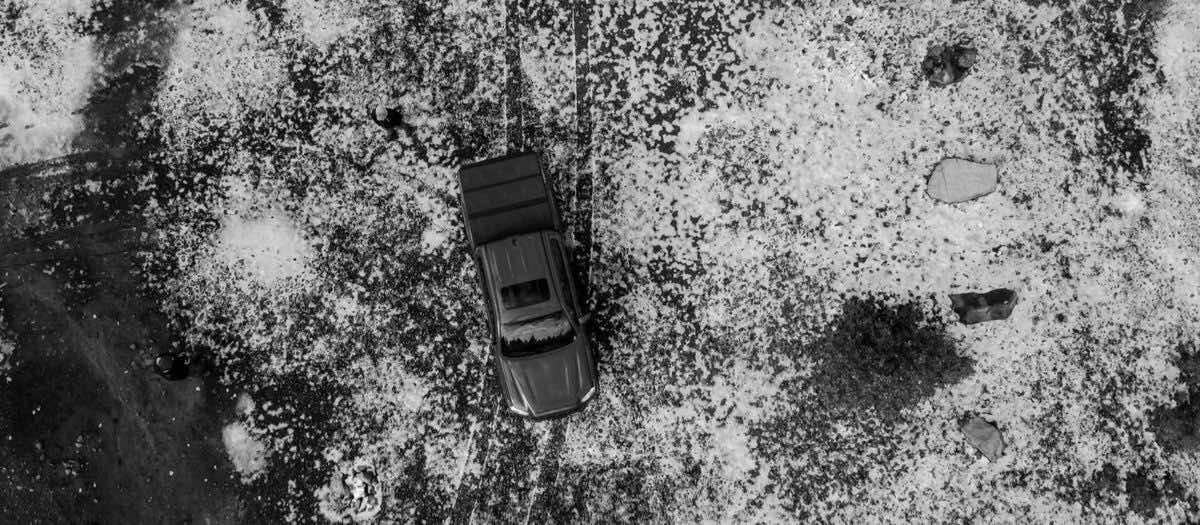 Ασπρόμαυρη εικόνα από ψηλά, αυτοκίνητο μέσα σε πεσμένο χαλάζι
