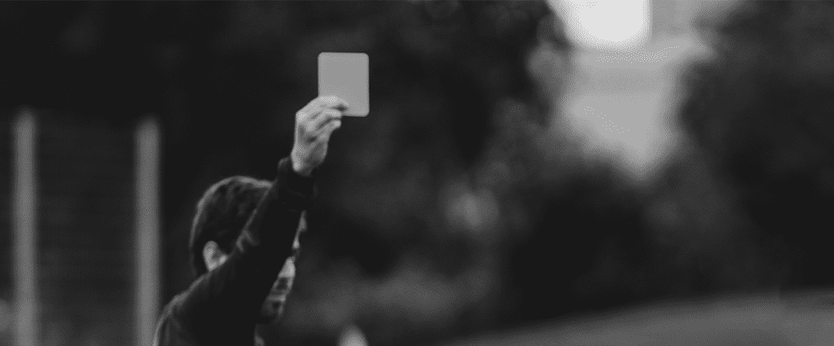 Ασπρόμαυρη εικόνα, διαιτητής δίνει σε παίκτη κάρτα