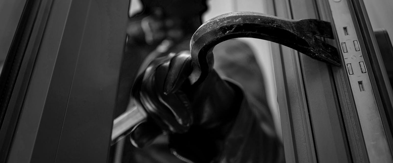 ασπρόμαυρη εικόνα, διαρρήκτης ανοίγει πόρτα με λοστό