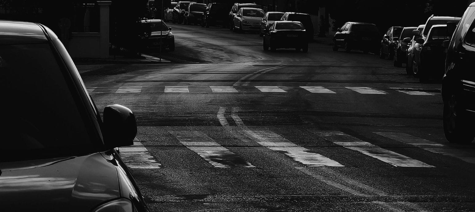 ασπρόμαυρη εικόνα δρόμου, άσφαλτος και διαβάσεις πεζών χωρίς κανέναν άνθρωπο, αδρές γραμμές αυτοκινήτων 