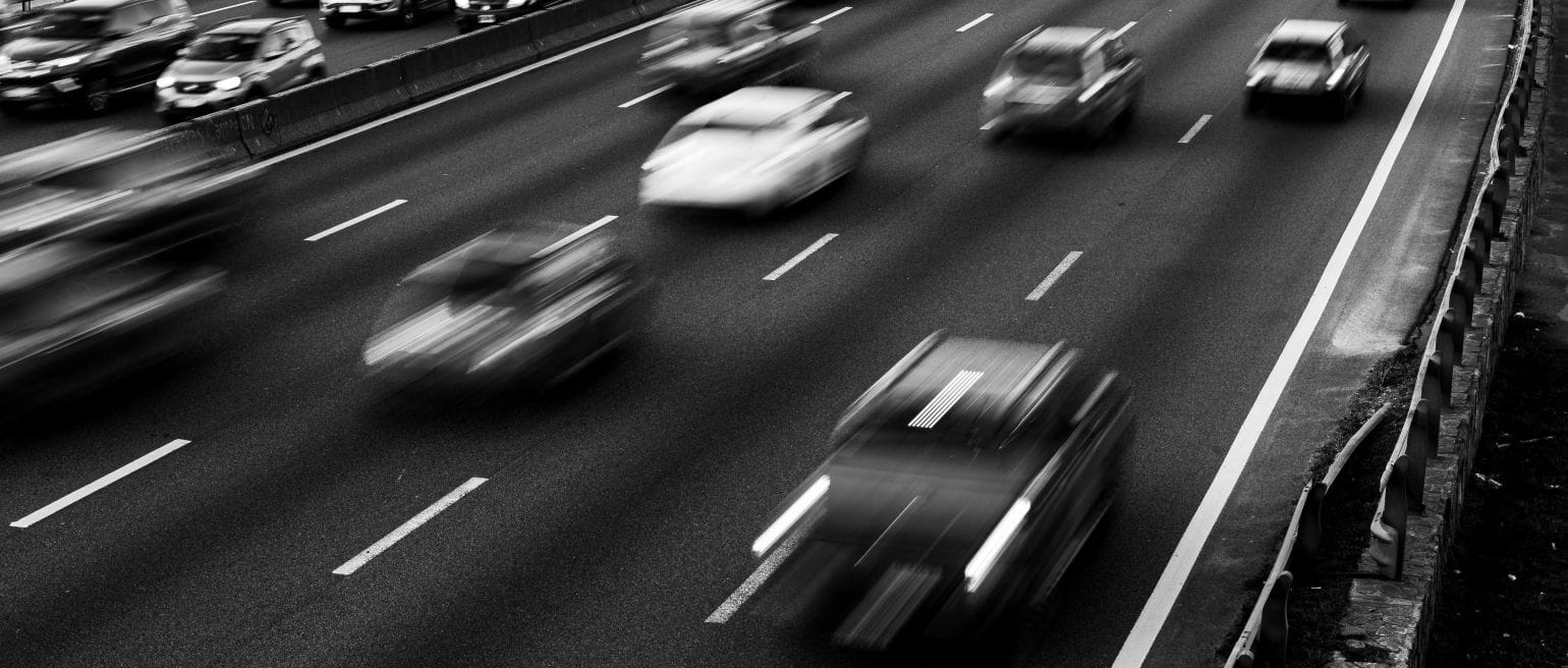 ασπρόμαυρη εικόνα από δρόμο με πολλές λωρίδες κυκλοφορίας, αυτοκίνητα εν κινήσει και προς τις δύο κατευθύνσεις