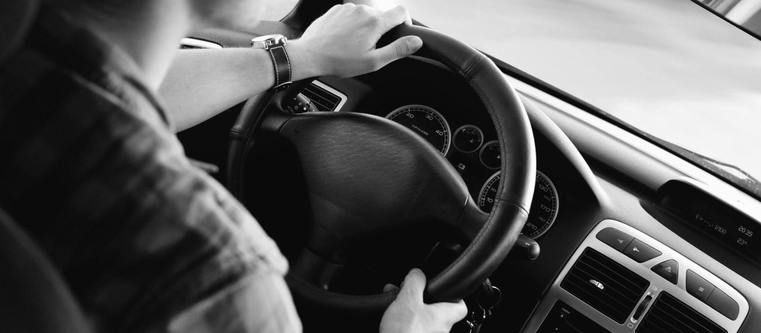 ασπρόμαυρη εικόνα, οδηγός αυτοκινήτου με τα χέρια στο τιμόνι, οδήγηση υπό την επήρεια αλκοόλ και κάλυψη ασφάλειας αυτοκινήτου