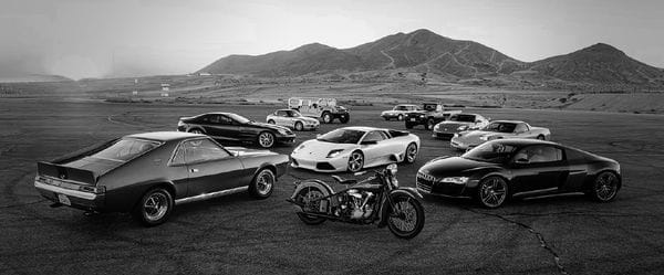 Αυτοκίνητα vintage και μία μηχανή με φόντο έρημο τοπίο και βουνά