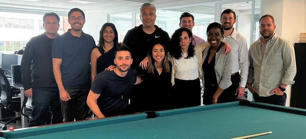 Η ομάδα της Hellas Direct με τους φοιτητές του Harvard πίσω από τραπέζι μπιλιάρδου 