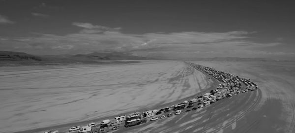 ασπρόμαυρη εικόνα με τεράστια ουρά αυτοκινήτων μέσα στην έρημο της Νεβάδα