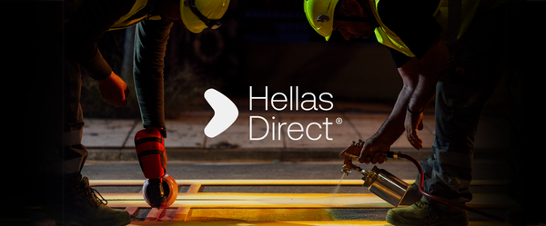 Νύχτα στον δρόμο μέλη του συνεργείου βάφουν ξεθωριασμένη διάβαση, στη μέση logo Hellas Direct